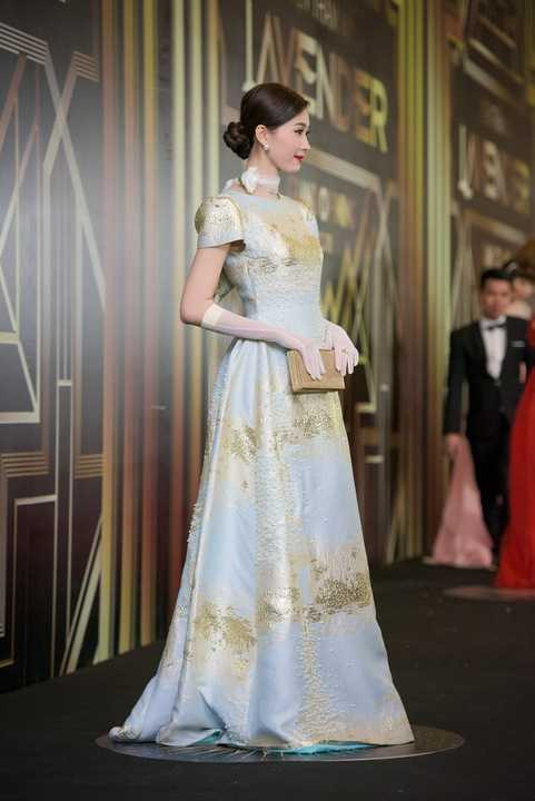 Để phối với chiếc đầm ánh nhũ, Đặng Thu Thảo chọn khăn quàng cổ cách điệu và găng tay ton sur ton để tăng thêm nét yêu kiều và quý phái.