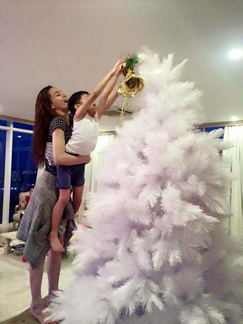 Dù chiều cao khiêm tốn nhưng anh chàng cũng muốn tự tay gắn quả chuông xinh xắn lên cây thông sau khi được mẹ giúp sức. 