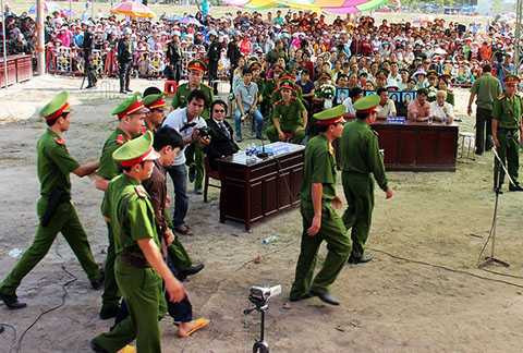 Được dẫn giải vào tòa, khi đi ngang qua di ảnh của 6 nạn nhân, Dương cúi gầm mặt để né tránh trong sự la ó của người nhà bị hại và hàng nghìn người.