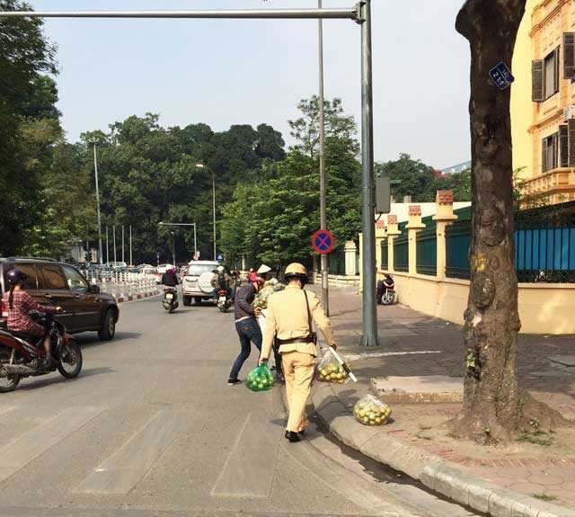 Ấm lòng hình ảnh CSGT nhặt cam giúp người dân