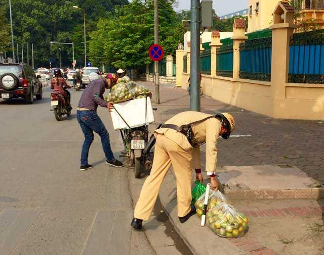 Ấm lòng hình ảnh CSGT nhặt cam giúp người dân