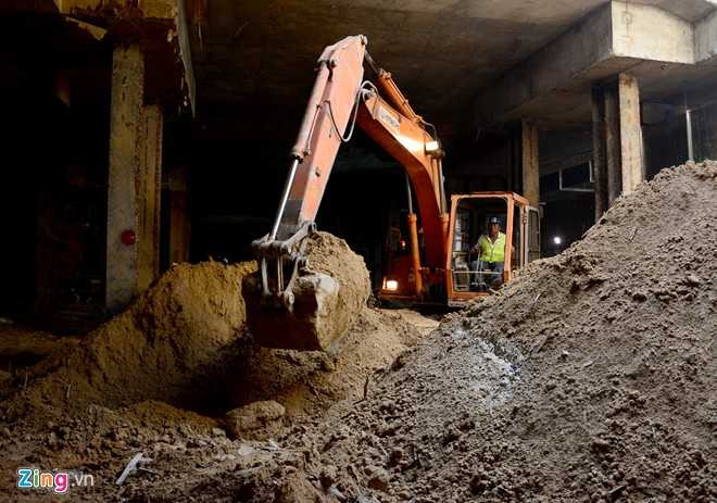 Một chiếc máy xúc khác gom đất trong hầm thành đống ngay dưới lỗ mở để đưa lên trên. Chỉ huy trưởng Lê Thanh Lê cho biết, công nhân đào đất thi công sàn B1 chia ra thành nhiều tốp, một tốp ở vị trí dưới lòng đường Nguyễn Huệ, một tốp dưới lòng đường Pasteur, sau đó sẽ thông với nhau. Công việc đào đất diễn ra cả ngày và đêm, mỗi ngày đào được hơn 500 m3.