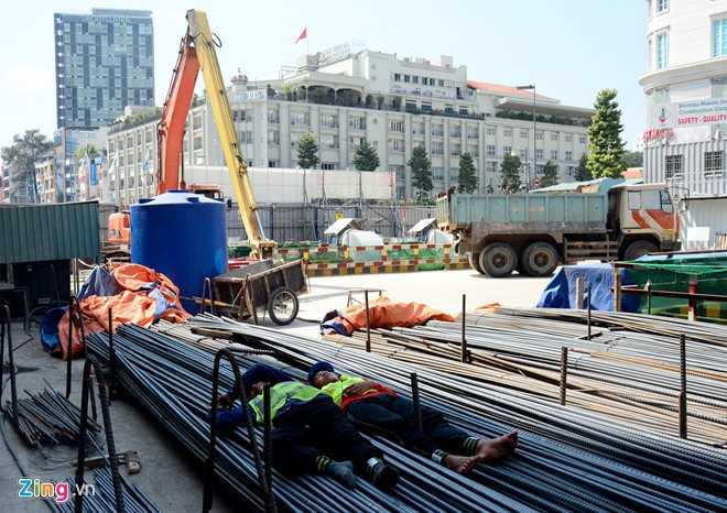 Nhiều công nhân tranh thủ ngủ vào giờ nghỉ trưa ngay trên những bó sắt ở công trường.