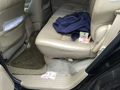 Một số tờ tiền mệnh giá 50.000 đồng, 100.000 đồng rơi vãi ở trong xe. Ảnh: Minh Thùy