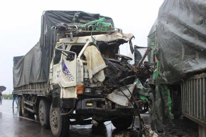 Sau cú đâm, đầu xe tải nát bét, tài xế xe tải trọng thương.