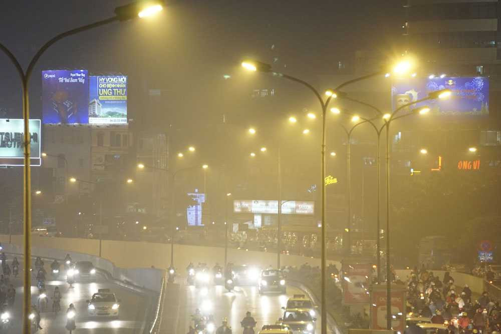 Nhìn vào các bóng đèn chiếu sáng, thấy rất rõ màn sương đang bao trùm thành phố.