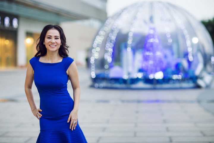 Bà mẹ một con thích thú đứng tạo dáng, khoe khéo eo thon với bộ đầm liền màu xanh cobalt có chi tiết xếp li ở phần eo giúp cô trông gọn gàng hơn. 