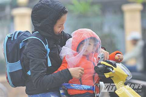 Trẻ em được cha mẹ che chắn kĩ càng để tránh sương, hơi ẩm làm ảnh hưởng tới sức khỏe.