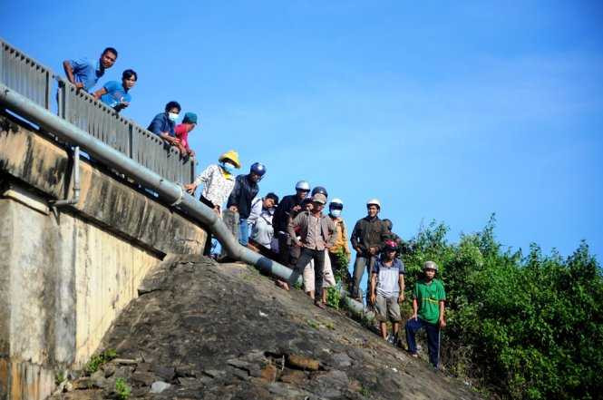 Nhiều người dân đứng theo dõi lực lượng chức năng trục vớt đầu đạn. Ảnh: Lâm Thiên