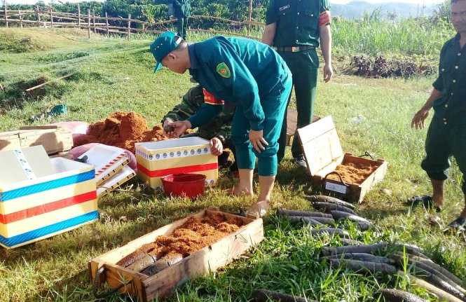 Lực lượng chức năng xếp các thùng chứa đầu đạn lên xe mang đi tiêu hủy. Ảnh: Lâm Thiên