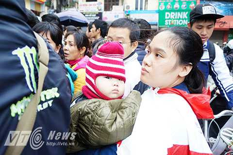 Vẻ căng thẳng và mệt mỏi của hai mẹ con khi phải chen lấn xô đẩy liên tục trong đám đông. 