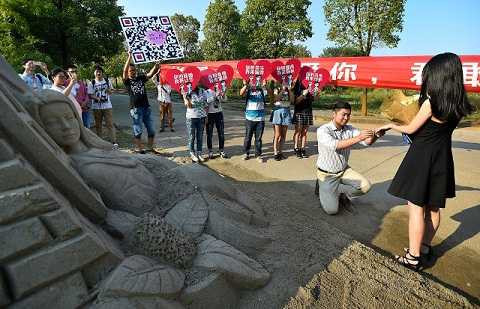 Chàng trai khắc hình người yêu lên cát để ngỏ lời cầu hôn