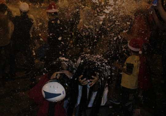 Hai cô gái phải cúi người, ôm mặt khi bị xịt tuyết vào mặt. Chị Lan Anh (sinh viên trường ĐH KHXH&NV) bức xúc: Mình đã la toáng lên phản đối mà nhiều người cứ xịt tuyết vào người, bay cả vào mắt mình.