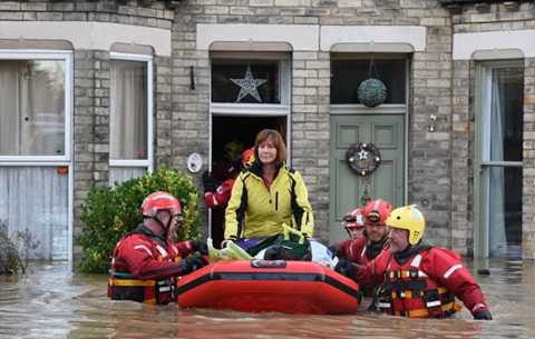 Một phụ nữ được sơ tán khỏi vùng lũ - Ảnh: North News