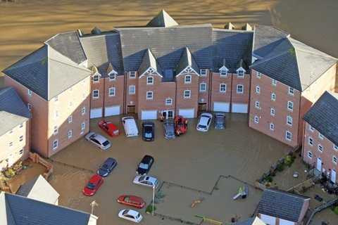  Lực lượng cứu hộ dùng thuyền đến từng nhà để sơ tán người dân bị kẹt trong vùng lũ - Ảnh: SWNS