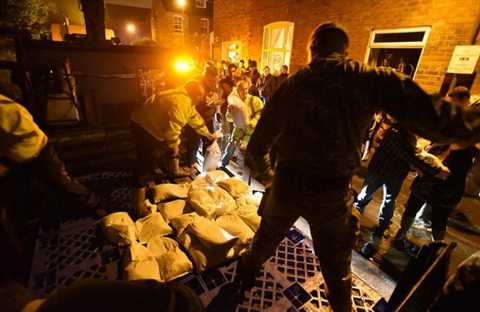 Người dân và binh sĩ Anh đang dùng bao cát chặn nước lũ trên đường Bishopthorp - Ảnh: Asadour Guzelian