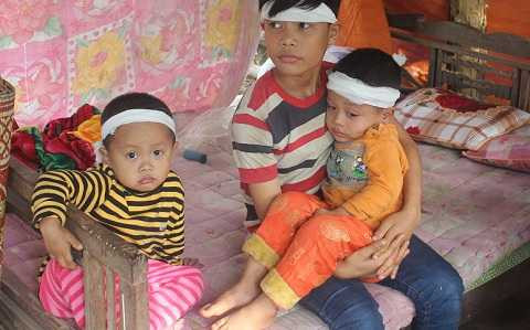 Từ ngày mẹ mất, 2 người con (bên trái và đang được bồng) luôn khóc uốn gọi mẹ