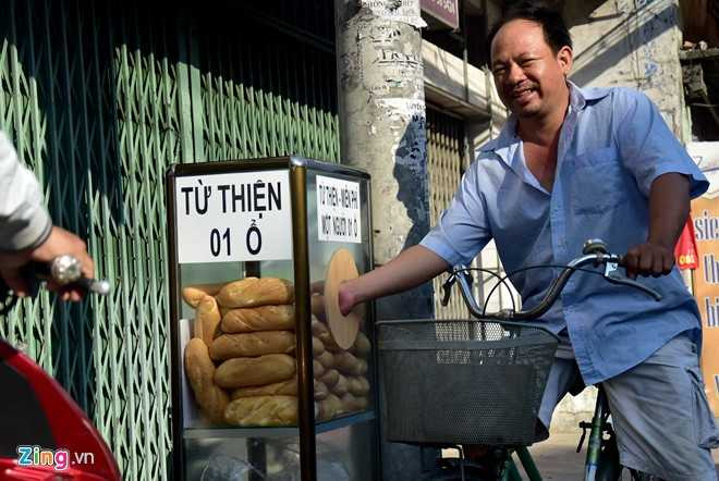 Ông Tư, một lao động tại khu phố ghé tủ, phấn khởi lấy 2 chiếc. Ngoài ra còn có một số người dân sống xung quanh cũng đến lấy bánh về.