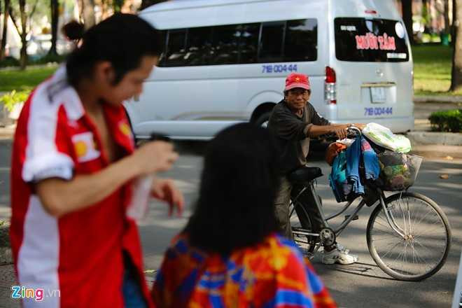 Ông Hai, người hay nhặt chai lọ ở khu vực này đi qua rất muốn cắt tóc nhưng phải về nhà hỏi ý vợ rồi mới quay lại.