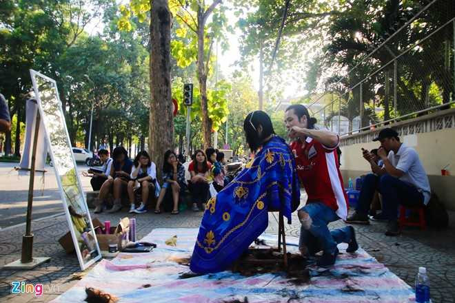 Trong khi Lê Tuấn quỳ gối cắt tóc cho chị ve chai thì rất nhiều bạn trẻ xếp hàng chờ đến lượt.