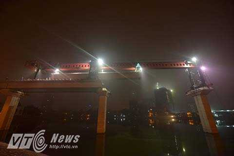 Dầm bê tông được cẩu ráp vào 2 trụ cầu giữa lòng hồ.