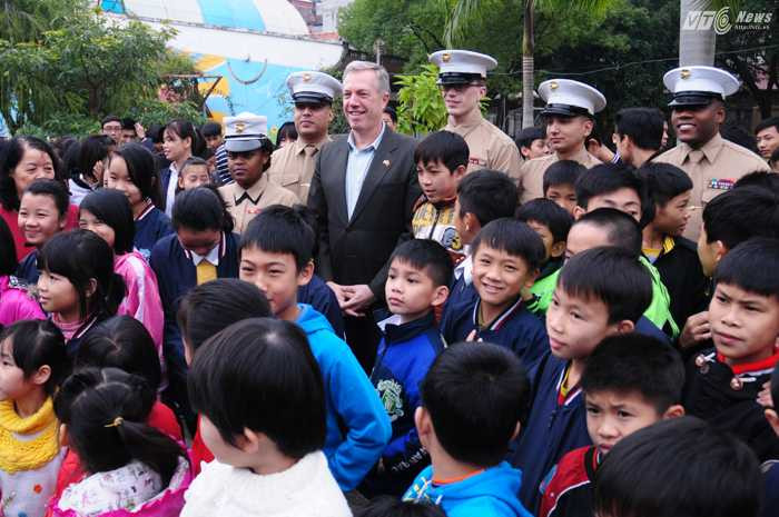 Các binh sỹ Lính thủy đánh bộ Mỹ chụp ảnh lưu niệm cùng Đại sứ Ted Osius và các trẻ em làng SOS - Ảnh: Tùng Đinh