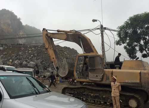 Máy xúc được huy động để giải phóng hàng trăm m3 đá từ trên núi cao đổ xuống. Ảnh: Lê Hoàng.