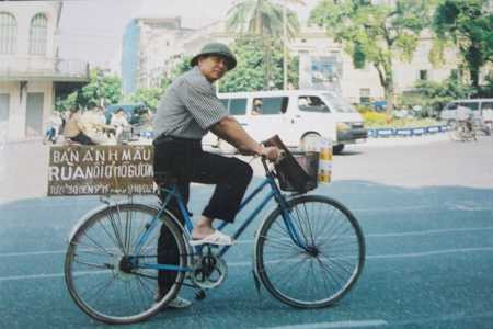 Ông Lưu Đức Ngò trong một lần đạp xe đi bán ảnh Cụ Rùa