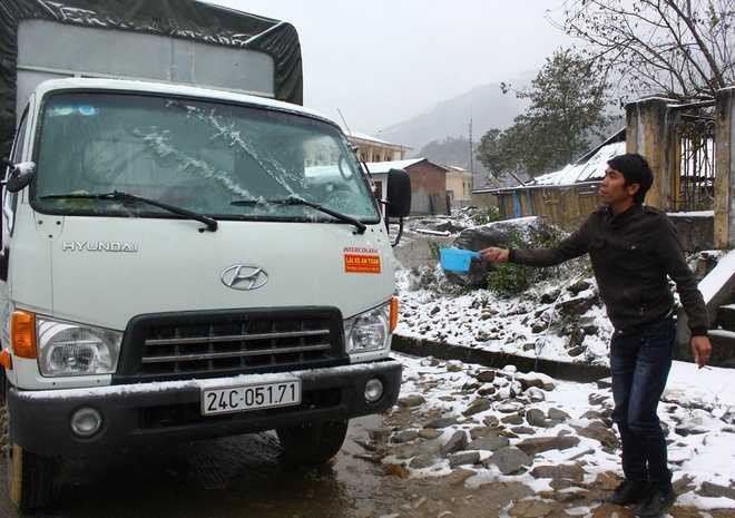 Múc nước sôi dội vào kính cho lớp tuyết nhanh tan.