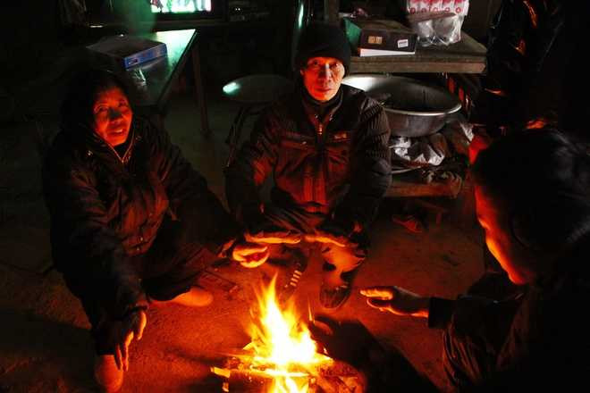 Hạn chế ra ngoài, ngồi quây quần bên đống lửa là cách chống rét thông dụng của nhiều người dân Y Tý (huyện Bát Xát).