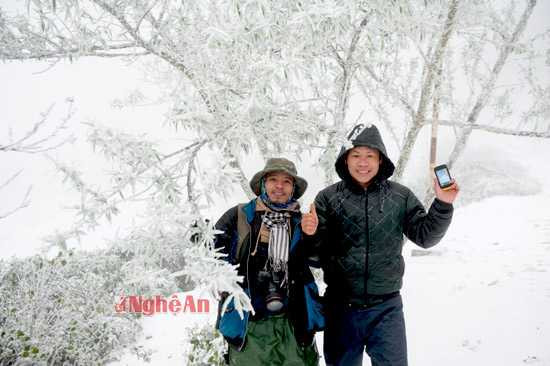 Mọi người thích thú lưu lại những giây phút hiếm hoi trước cảnh băng tuyết ở xã Na Ngoi (Kỳ Sơn). Trong ảnh: anh Hà Văn Khôi (phải) - Ban nông nghiệp xã Na Ngoi cùng dân phượt bên cây đào trước Trạm biên phòng Buộc Mú - đồn Biên Phòng Na Ngoi
