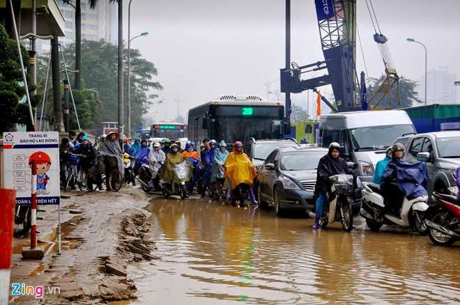 Nước ứ đọng chiếm phần lớn lòng đường vốn đã nhỏ hẹp vì công trường khiến xe cộ gần như không thể lưu thông.