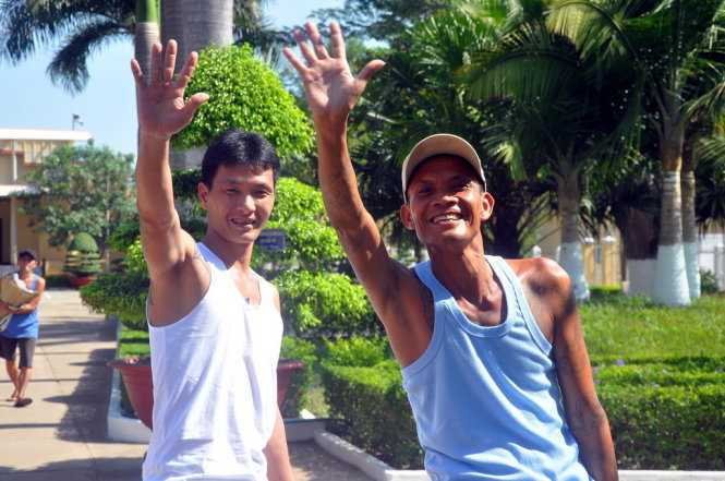 Hai người được tha tù trước thời hạn vẫy chào và động viên những người ở lại cố gắng cải tạo tốt để hưởng chính sách khoan hồng - Ảnh: Đông Hà