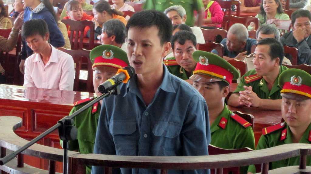 Bị cáo Nghĩa trước tòa và hàng trăm người dân tham dự phiên tòa - Ảnh: Thành Nhơn