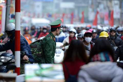 Dù đi bộ sang đường đúng quy định nhưng anh lính trẻ đành bất lực nhìn biển người tham gia giao thông