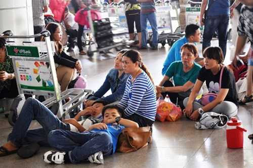 Nhiều gia đình mỏi mòn ngồi bệt dưới sàn gạch. Ảnh Việt Văn