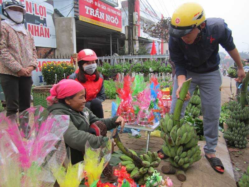 Bà Hồ Thị Nhơn (trái, đội khăn đỏ trên đầu) đem chuối ra khu vực gần chợ Khe Sanh bán kiếm tiền mua mắm muối