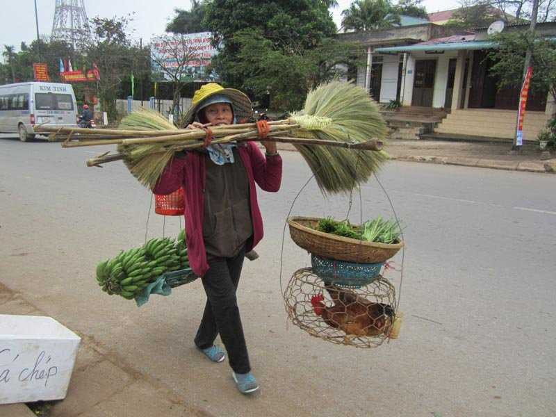 Một phụ nữ vùng cao quang gánh các nông sản mình làm được ra chợ rao bán để kiếm Tết cho gia đình