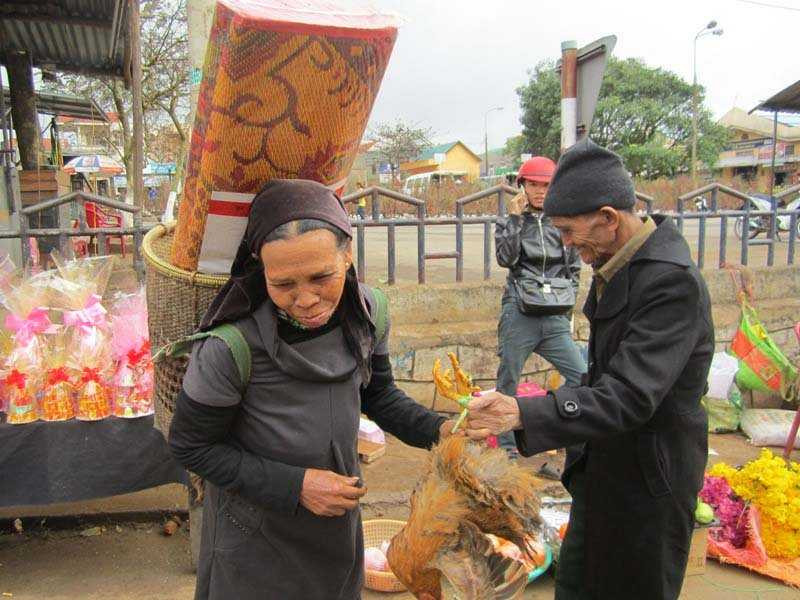 Vợ chồng ông Ăm Nhăm (khóm 5, thị trấn Khe Sanh) vừa xách con gà mua ở chợ về cúng tất niên vừa ngượng ngịu trước ống kính máy ảnh