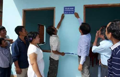 Mọi người cùng vui khi tấm biển nhà mới được ông Nén và nhà báo Nguyễn Đại Dương, Phó trưởng Ban Hợp tác truyền thông, báo Tiền Phong gắn lên tường trước nhà.