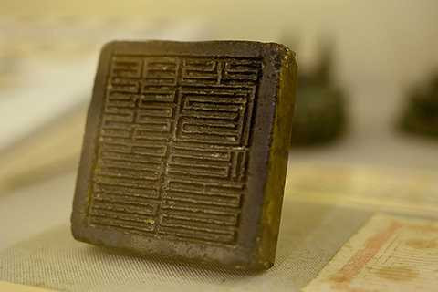 Ấn đồng Môn Hạ Sảnh, được đúc năm 1377 dưới thời vua Trần Duệ Tông. Chiếc ấn hình vuông, có núm hình chữ nhật. Hai bên cạnh lưng ấn khắc hai dòng chữ Hán. Bên phải có 4 chữ, phiên âm Môn Hạ Sảnh ấn (ấn của Sảnh Môn Hạ). Bên trái khắc 11 chữ, phiên âm Long khánh ngũ niên ngũ nguyệt nhị thập tam nhật tạo (chế tạo ngày 23 tháng 5, năm thứ 5 niên hiệu Long Khánh). Môn Hạ Sảnh ấn được dùng để đóng trên những văn bản hành chính quan trọng của triều đình từ đời Trần Phế Đế về sau, là hiện vật liên quan đến tổ chức hành chính trung ương. Sảnh Hạ Môn là cơ quan nằm trong bộ ba Tam sảnh của chính quyền trung ương, gồm: sảnh Thượng thư, sảnh Trung thư và sảnh Môn hạ. Trong đó, sảnh Môn hạ là cơ quan thân cận nhà vua, có nhiệm vụ giữ bảo ấn, truyền lệnh của vua tới các quan và các công việc lễ nghi trong cung. Chức quan này do những đại thần tài giỏi đảm nhiệm. Ấn đồng Môn Hạ Sảnh, được đúc năm 1377 dưới thời vua Trần Duệ Tông. Chiếc ấn hình vuông, có núm hình chữ nhật. Hai bên cạnh lưng ấn khắc hai dòng chữ Hán. Bên phải có 4 chữ, phiên âm Môn Hạ Sảnh ấn (ấn của Sảnh Môn Hạ). Bên trái khắc 11 chữ, phiên âm Long khánh ngũ niên ngũ nguyệt nhị thập tam nhật tạo (chế tạo ngày 23 tháng 5, năm thứ 5 niên hiệu Long Khánh). Môn Hạ Sảnh ấn được dùng để đóng trên những văn bản hành chính quan trọng của triều đình từ đời Trần Phế Đế về sau, là hiện vật liên quan đến tổ chức hành chính trung ương. Sảnh Hạ Môn là cơ quan nằm trong bộ ba Tam sảnh của chính quyền trung ương, gồm: sảnh Thượng thư, sảnh Trung thư và sảnh Môn hạ. Trong đó, sảnh Môn hạ là cơ quan thân cận nhà vua, có nhiệm vụ giữ bảo ấn, truyền lệnh của vua tới các quan và các công việc lễ nghi trong cung. Chức quan này do những đại thần tài giỏi đảm nhiệm.