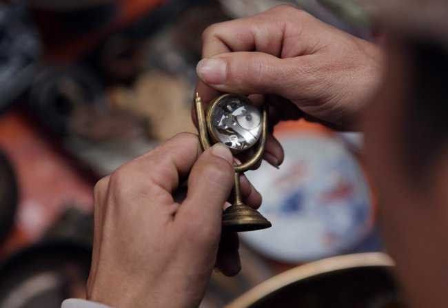 Người đàn ông đang ngắm kĩ từng chi tiết chiếc đồng hồ có hình dáng lạ mắt