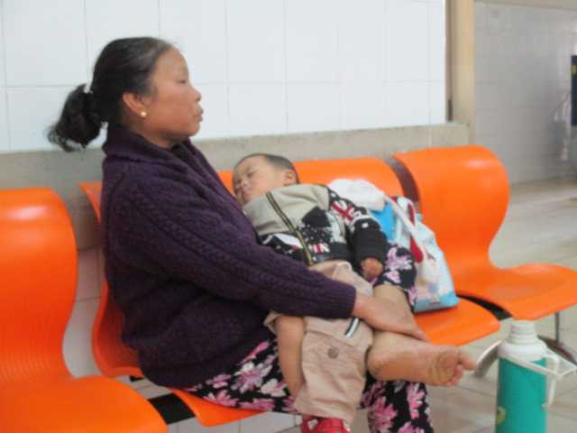 Bà Thêm vừa bồng vừa lo lắng cho tình trạng sức khỏe của cháu nội.