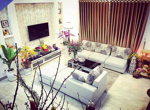 Phòng khách được bày biện ngăn nắp với bộ salon, tivi và dàn loa sang trọng.