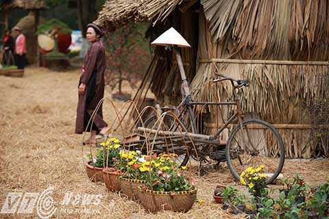 Đình ảnh cổng làng, ụ rơm, xe kéo… quen thuộc được sắp đặt khéo léo giữa muôn vàn sắc hoa.
