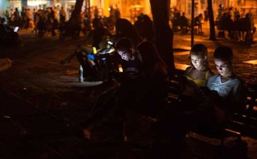 Thanh niên Cuba vào Internet bằng thiết bị di động, tại một điểm phát wi-fi công cộng