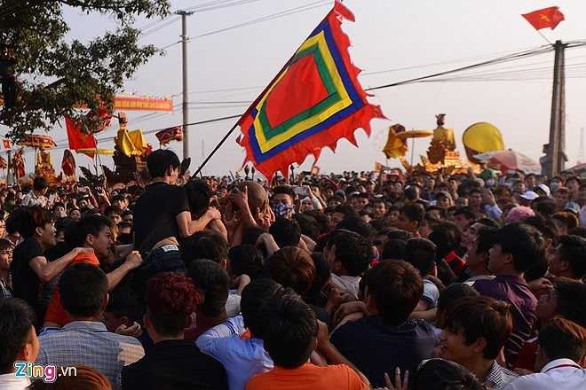 16h chiều, bô lão là những người thủ cầu bắt đầu tung quả phết ra trước cổng đình, ngay lập tức hàng trăm thanh niên xông vào cướp. (Nguồn: Zing)