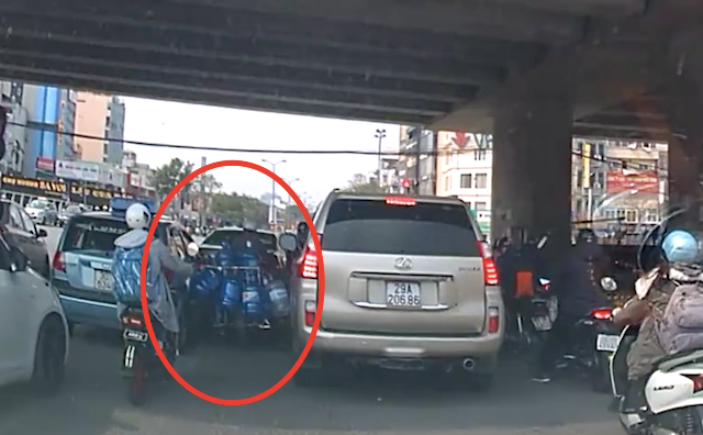 chiếc xe chở nước cố gắng luồn lách giữa 2 ô tô (ảnh chụp màn hình)