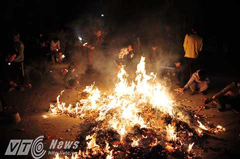 Toàn bộ vàng mã được hóa tạo thành một đống lửa to trước cổng đình để mọi người cùng đến xin lửa.