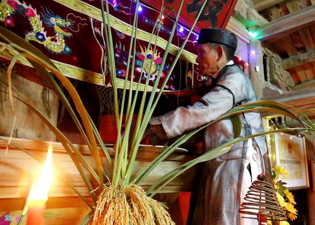 Cụ Nguyễn Thành Ngữ, thủ từ trông coi miếu Trò làng Trám trèo lên nơi cất giấu linh thiêng trong ngôi miếu để lấy tráp gỗ sơn đỏ (trong đựng nõ và nường) mang xuống để trước ban thờ để làm lễ.